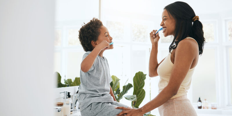 mother and son brushing their teeth using at home dental care tips from Peter Family & Cosmetic Dentistry