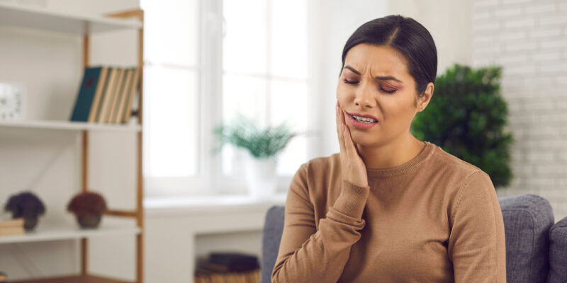 woman touching her jaw with dental pain in independence kentucky